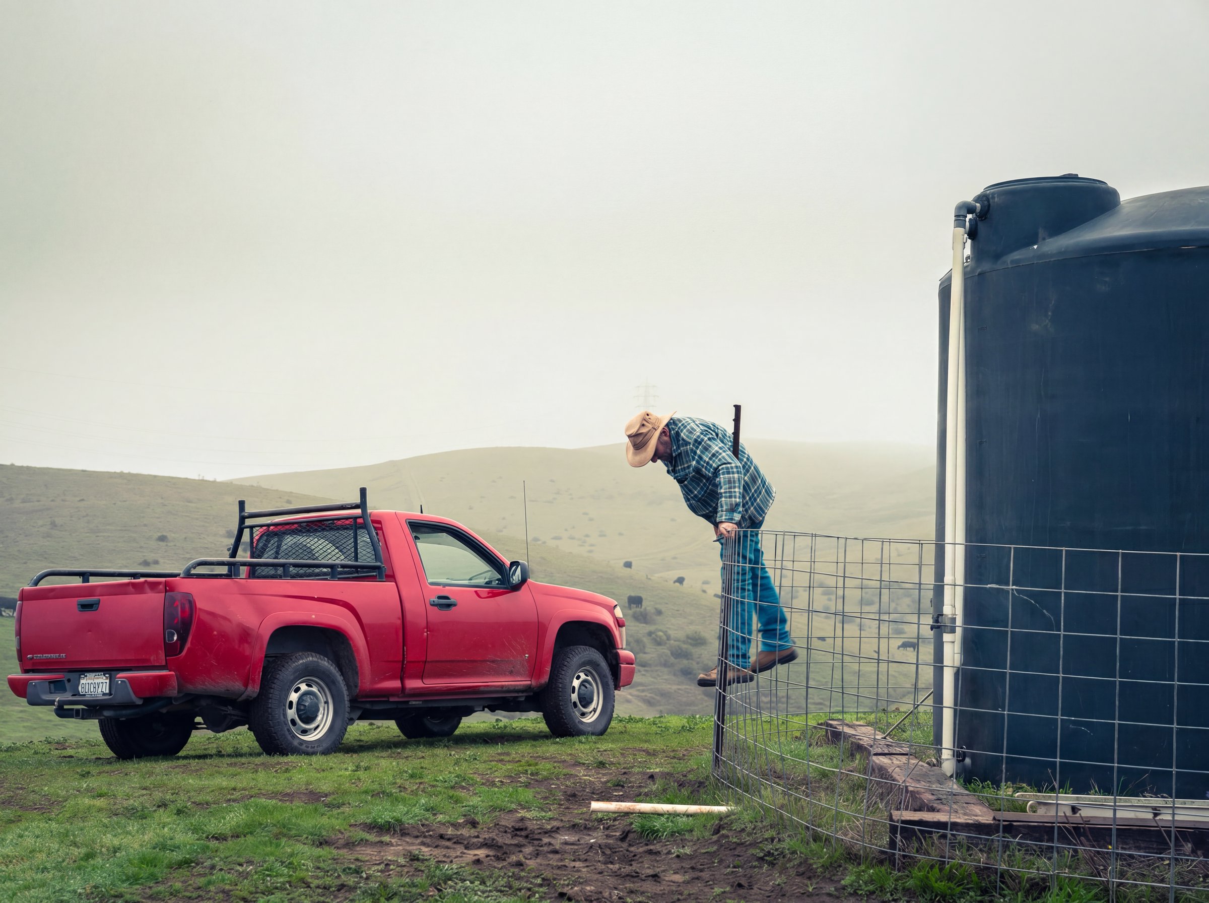Gary climbing the fence to check his tank for the last time