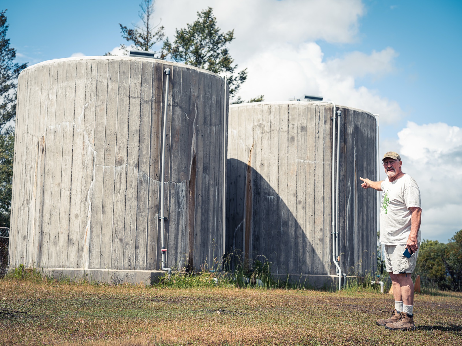 Owner pointing at his two concrete tanks
